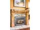 Close-up of a beautiful, wood-burning fireplace with a carved wooden mantle and tile hearth at 9045 W Ithaca Pl, Denver, CO 80235