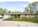 Charming ranch-style home with a well-manicured lawn, a covered porch, and an attached garage at 9045 W Ithaca Pl, Denver, CO 80235