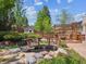 Scenic backyard with a charming wooden bridge, fish pond, pergola, and mature landscaping at 3138 E Otero Cir, Centennial, CO 80122