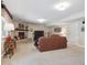 Cozy finished basement with brick fireplace, plush seating, and adjacent media center at 3138 E Otero Cir, Centennial, CO 80122