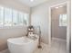 Luxurious soaking tub with floor mounted faucet and bright window in a modern bathroom at 3138 E Otero Cir, Centennial, CO 80122