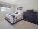 Comfortable bedroom with large dresser, cozy bed with quilts, and a window with blinds at 3138 E Otero Cir, Centennial, CO 80122