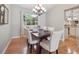 Bright dining room with hardwood floors, chandelier, and large window overlooking a trellised outdoor area at 3138 E Otero Cir, Centennial, CO 80122