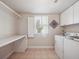 Functional laundry room with washer, dryer, built-in shelving, and a bright window at 3138 E Otero Cir, Centennial, CO 80122