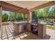 Outdoor kitchen featuring a built-in BBQ, countertop space, and a shaded pergola area for gatherings at 3138 E Otero Cir, Centennial, CO 80122