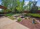 Landscaped backyard with a tranquil pond, wooden bridge, lush greenery, and outdoor dining at 3138 E Otero Cir, Centennial, CO 80122