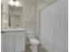 Well-lit bathroom features a white vanity, toilet, shower with curtain and modern fixtures at 45840 Laceleaf Dr, Bennett, CO 80102