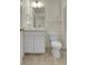 Bright bathroom featuring a toilet, white vanity with a modern faucet and decorative lighting at 45840 Laceleaf Dr, Bennett, CO 80102