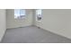 Sunlit bedroom with plush carpeting, dual windows overlooking the neighborhood, and neutral walls at 45840 Laceleaf Dr, Bennett, CO 80102