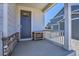 Welcoming front porch with stone accents, a dark door and ample space for outdoor seating at 45840 Laceleaf Dr, Bennett, CO 80102