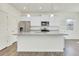 Bright kitchen with a large island, stainless steel appliances, and open shelving at 45840 Laceleaf Dr, Bennett, CO 80102