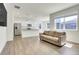 Spacious open-concept living room featuring wood floors, natural light, and a comfortable seating area at 45840 Laceleaf Dr, Bennett, CO 80102