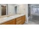 Bathroom featuring dual sinks, a large mirror, and classic tiled tub-shower at 275 Pontiac St, Denver, CO 80220