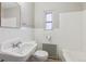 Cozy, tiled bathroom featuring classic fixtures and a radiator near the shower at 275 Pontiac St, Denver, CO 80220