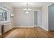 Bright dining room showcasing hardwood floors, a modern chandelier, and a doorway to another room at 275 Pontiac St, Denver, CO 80220