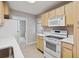 Clean kitchen with light wood cabinets, modern appliances, and a view into another room at 275 Pontiac St, Denver, CO 80220