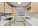 Well-lit kitchen featuring light wood cabinetry, white countertops, and stainless-steel appliances at 275 Pontiac St, Denver, CO 80220