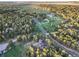 An aerial view of a property nestled within a lush forest, featuring a winding road and neighboring homes at 18330 Archers Dr, Monument, CO 80132