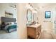 Bathroom featuring double sinks, oval mirrors, wood vanity, and a view into the bedroom beyond at 18330 Archers Dr, Monument, CO 80132