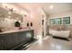 Well-lit bathroom featuring a double vanity, soaking tub, and natural light at 18330 Archers Dr, Monument, CO 80132