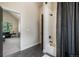 A full bathroom with black tile floor, a tub with a shower and an open doorway to the living room at 18330 Archers Dr, Monument, CO 80132
