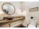 Stylish bathroom with a wood countertop, round mirror, pendant lighting, and a rustic-chic design at 18330 Archers Dr, Monument, CO 80132