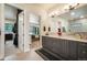 Luxury bathroom with dual vanities, a large mirror, and access to the walk-in closet and main bedroom at 18330 Archers Dr, Monument, CO 80132