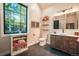 Bright bathroom featuring a wood vanity, open shelving, and a large window offering ample natural light at 18330 Archers Dr, Monument, CO 80132