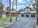 Stunning exterior of a modern luxury home featuring stone accents, a three-car garage, and a well-manicured front yard at 18330 Archers Dr, Monument, CO 80132