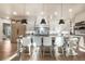 Bright kitchen boasts an oversized island with seating, a chef's range and custom cabinetry at 18330 Archers Dr, Monument, CO 80132