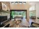Cozy living room with stone fireplace, and sliding glass doors that open to an outdoor covered patio at 18330 Archers Dr, Monument, CO 80132