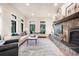 Spacious living room with stone fireplace, large windows, and white sofas with decorative pillows at 18330 Archers Dr, Monument, CO 80132