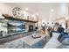 Bright living room featuring a stone fireplace, tv, and easy access to the kitchen at 18330 Archers Dr, Monument, CO 80132