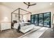 Spacious main bedroom with a four-poster bed, large sliding glass doors, and serene outdoor views at 18330 Archers Dr, Monument, CO 80132