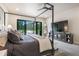 Sun-filled main bedroom featuring a large four-poster bed, TV, and backyard views through a sliding glass door at 18330 Archers Dr, Monument, CO 80132
