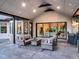 Covered outdoor patio with wicker seating, a stone fireplace, and a built-in grill at 18330 Archers Dr, Monument, CO 80132