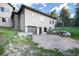 Home exterior showcasing the garage, partial stone facade, and the surrounding landscape, including some mature trees at 18330 Archers Dr, Monument, CO 80132