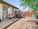 Backyard showing a table, mulch, trees, bushes, and a door to the house at 3450 N Harrison St, Denver, CO 80205