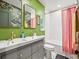 Stylish bathroom featuring dual sinks, a bathtub with shower, and eye-catching wallpaper at 3450 N Harrison St, Denver, CO 80205