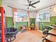 Bright bedroom featuring two windows with pink curtains, a ceiling fan, and a dark papasan chair at 3450 N Harrison St, Denver, CO 80205