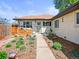 Lovely single-story home with a light green door and lush landscaping around the walkway to the front door at 3450 N Harrison St, Denver, CO 80205
