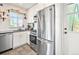 Bright kitchen features white cabinets, stainless steel appliances, and a view from the window at 3450 N Harrison St, Denver, CO 80205