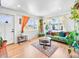 Bright living room with hardwood floors, green sofa, large windows, and neutral decor at 3450 N Harrison St, Denver, CO 80205