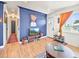 Cozy living room with hardwood floors, a large window, a blue accent wall, and stylish decor at 3450 N Harrison St, Denver, CO 80205
