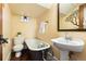 Cozy bathroom with a clawfoot tub, pedestal sink, and vintage-inspired decor at 1065 Jackson St, Denver, CO 80206