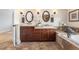 Bright bathroom featuring dual sinks with warm wood cabinets and granite countertops and a jacuzzi tub at 1065 Jackson St, Denver, CO 80206