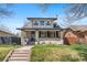 Charming two-story home featuring a well-manicured lawn, a brick walkway, and a welcoming front porch at 1065 Jackson St, Denver, CO 80206