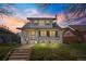 Charming two-story home featuring a well-manicured lawn, a brick walkway, and beautiful sunset views at 1065 Jackson St, Denver, CO 80206