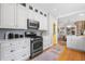 Well-lit kitchen featuring white cabinetry, modern appliances, and an open view to the dining area at 1065 Jackson St, Denver, CO 80206