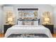 Main bedroom features a plush bed, matching nightstands, and an accent wall decor piece at 1065 Jackson St, Denver, CO 80206